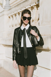 a lady wears a black leather jacket with white shirt and black mini skirt